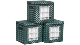 Two dark green ornament storage boxes with white snowflake designs on the bottom and one stacked on top with a transparent window, for the best ornament storage containers.