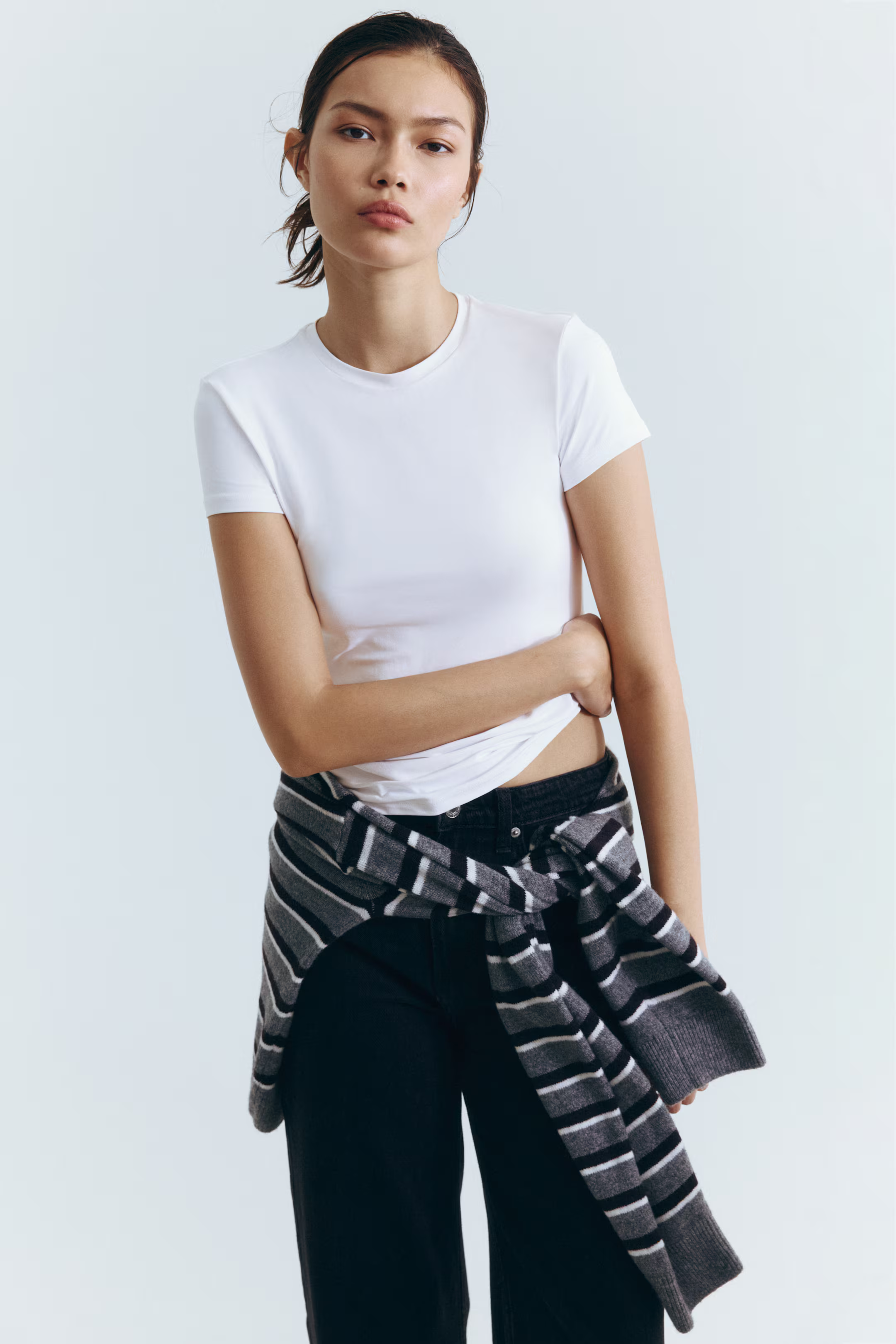 A model wearing a white H&amp;amp;M crew neck t-shirt.