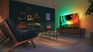 Philips Ambilight OLED TV displaying colourful scene in darkened room