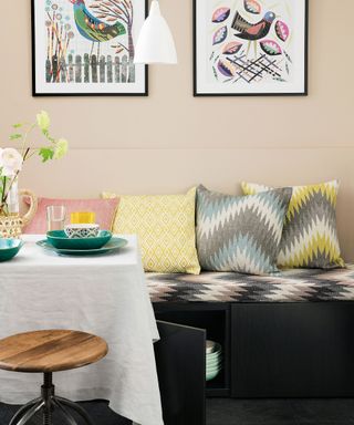 Black bench seat topped with patterned foam cushion in dining room