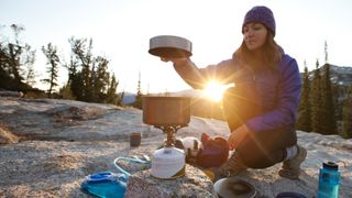 Woman cooking over camping stove
