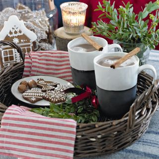 festive christmas hot chocolates served on a wicker tray with decorations and christmas themed cookies