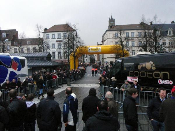 The riders make their way from their team buses down a cobbled street to Bruges' great market place, where the race starts