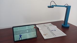 Ipevo VZ-X document camera on desk scanning book and the image appearing on a tablet