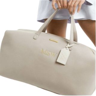 cream weekend bag held by a model with personalized detailing