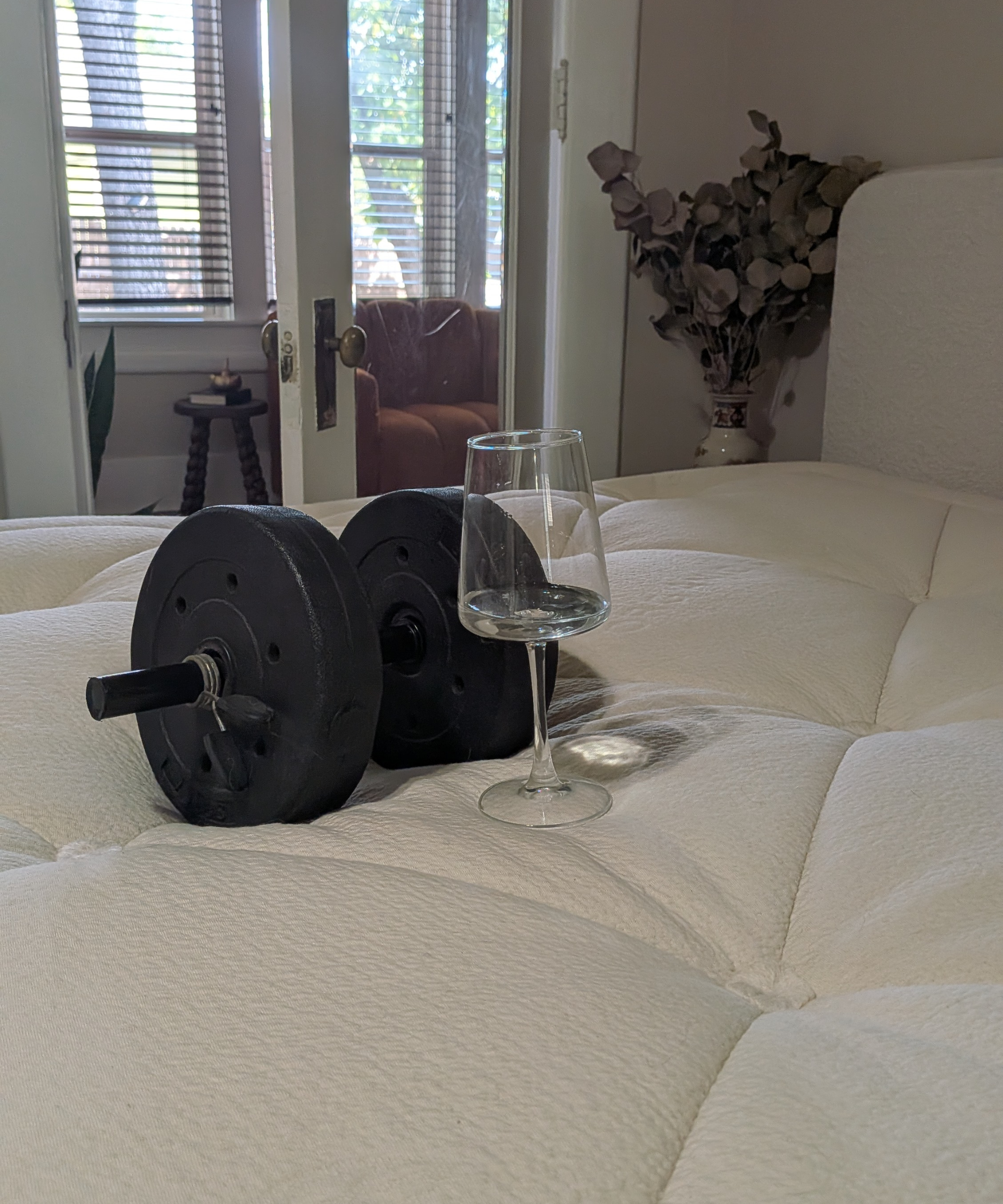 A wine glass and a dumbbell used to run a motion isolation test on the Avocado Luxury Organic Mattress.