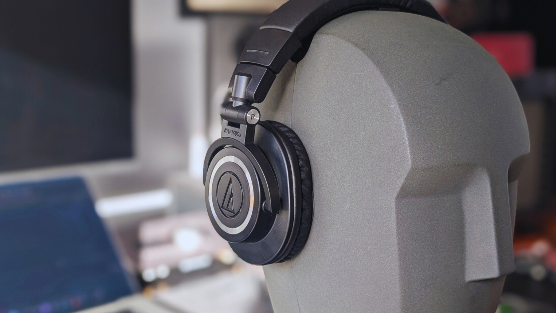 A pair of Audio-Technica ATH-M50X headphones on a Neumann KU 100 dummy head