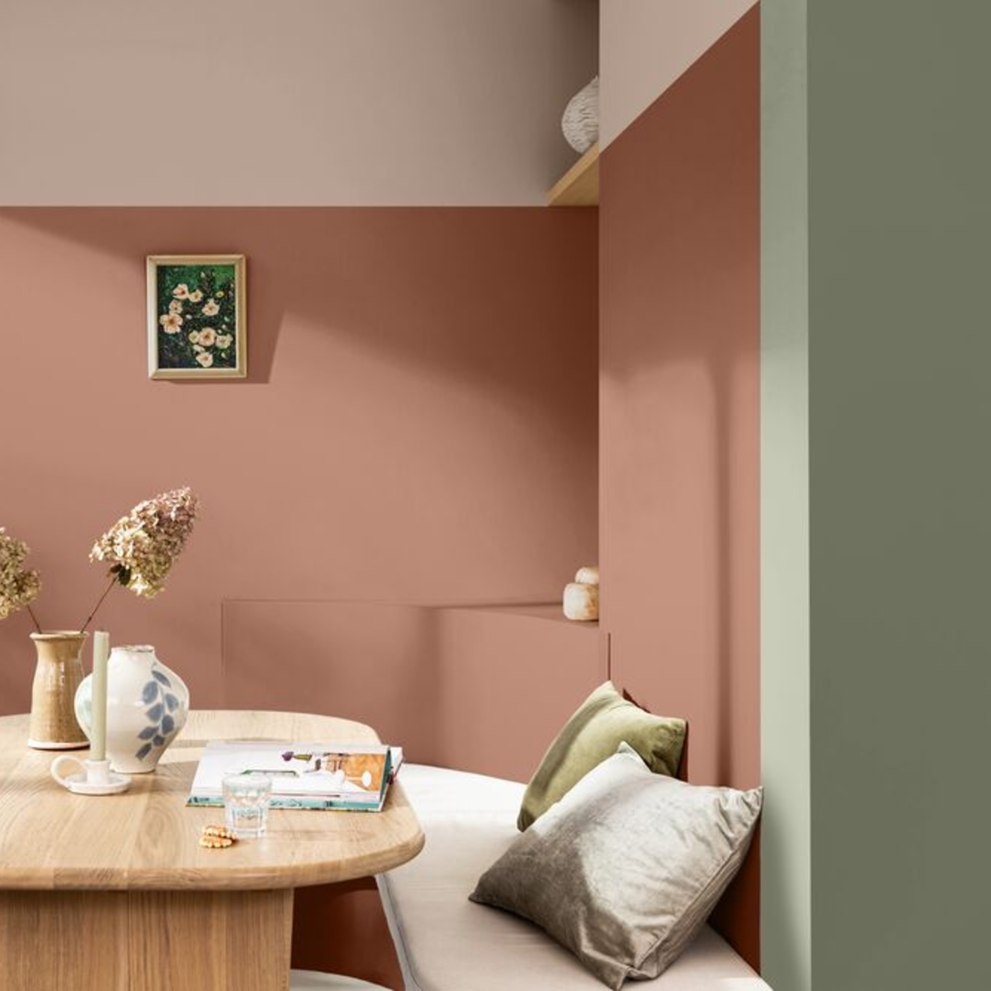 A dining nook painted with colour blocks of Dulux's Soulful Sage shade, an earthy pink and a light neutral