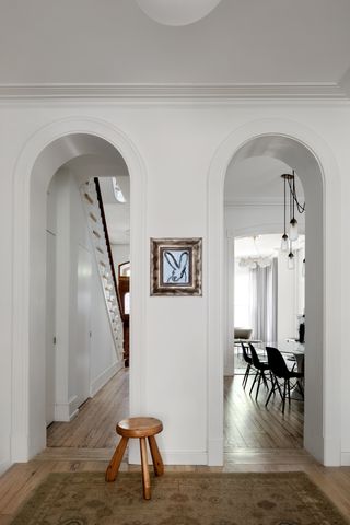 white hallway with wood flooring by Hendrick Interiors