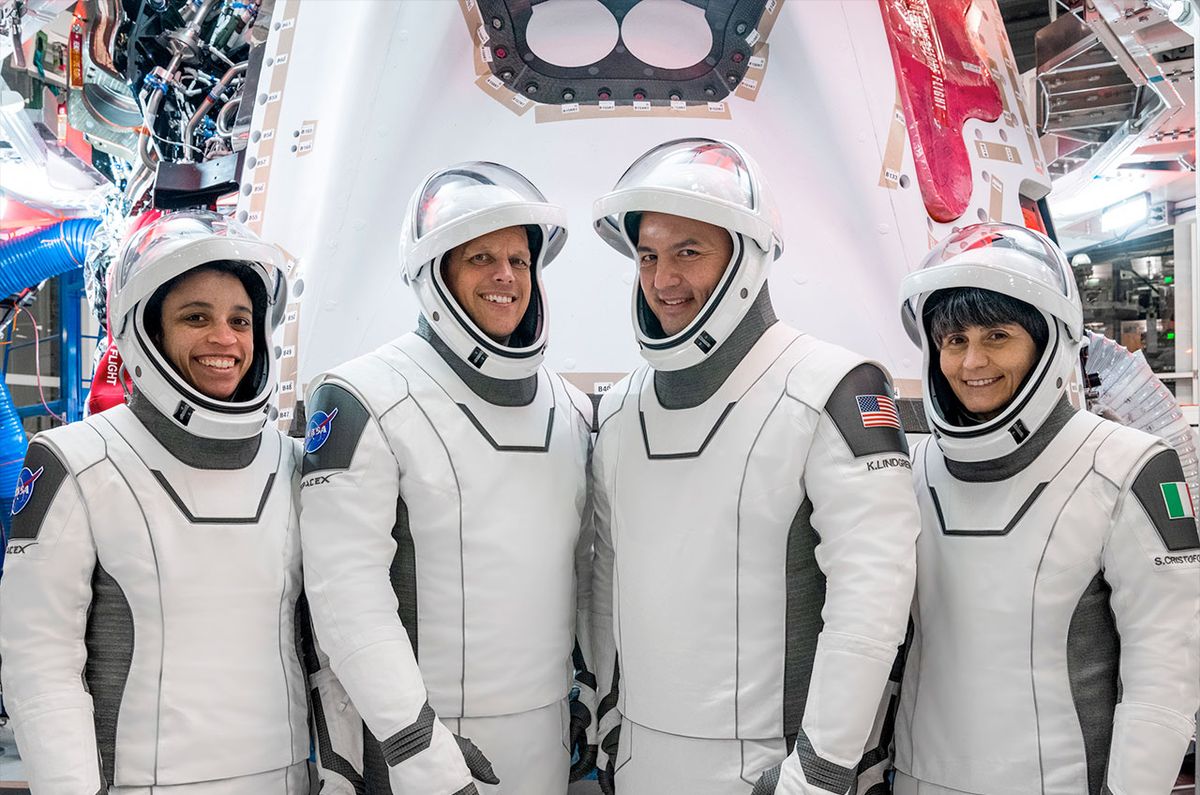 Crew-4 commander Kjell Lindgren (at right) with pilot Bob Hines, flanked by crewmates Jessica Watkins and Samantha Cristoforetti and backdropped by their Crew Dragon &quot;Freedom.&quot;