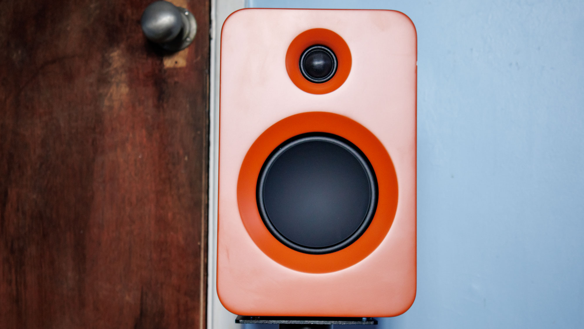 Straight on picture of the Kanto ren passive speaker in front of a door