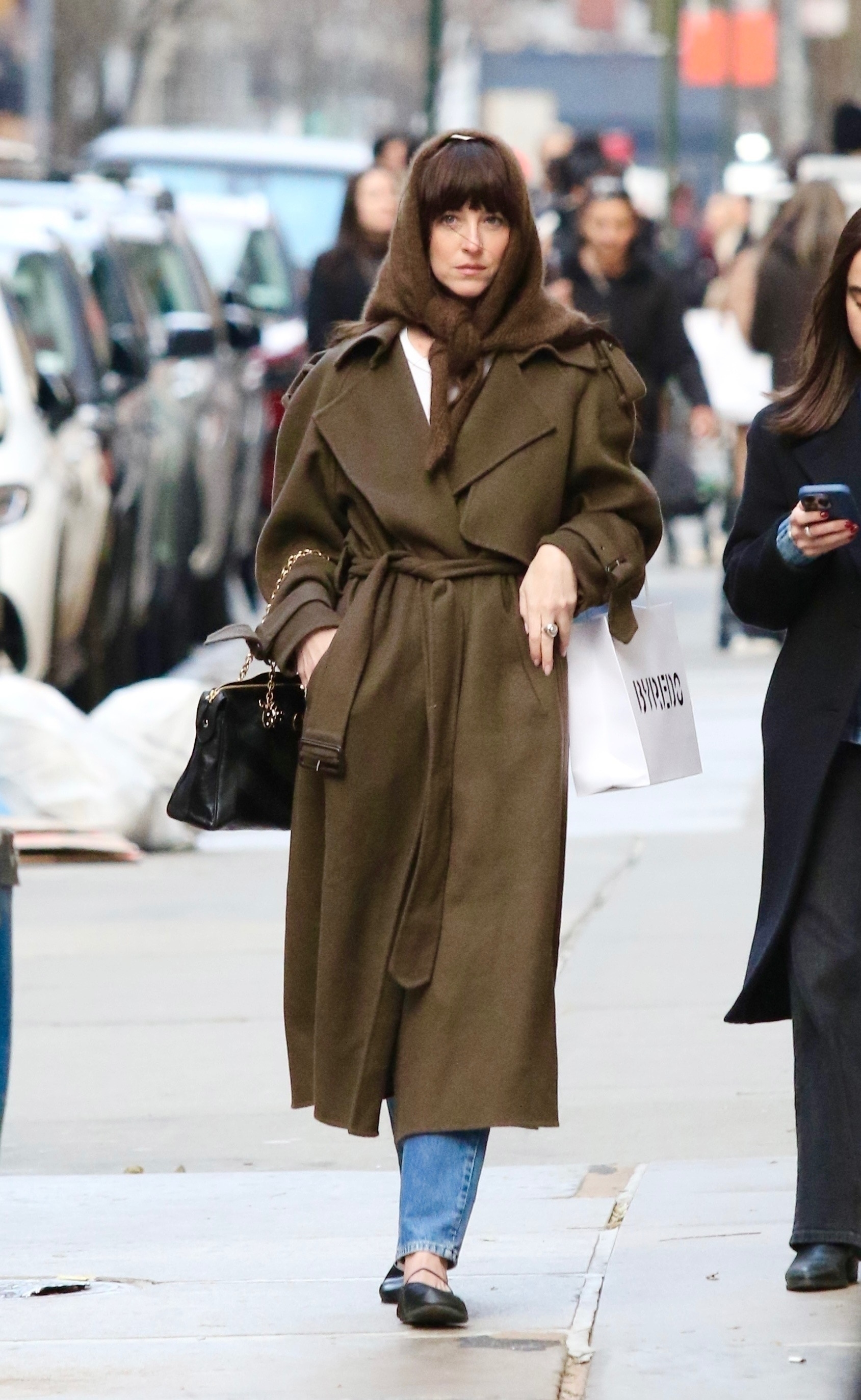 Dakota Johnson tested the triangle scarf trend with her wool The Row wrap coat and ballet flats