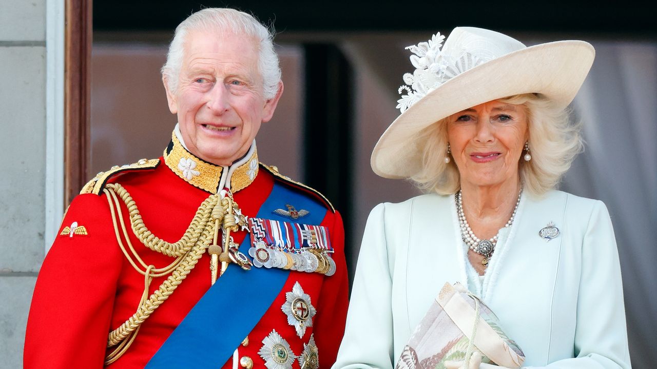 King Charles III, wearing his Irish Guards uniform, and Queen Camilla watch an RAF flypast from the balcony of Buckingham Palace after attending Trooping the Colour on June 15, 2024