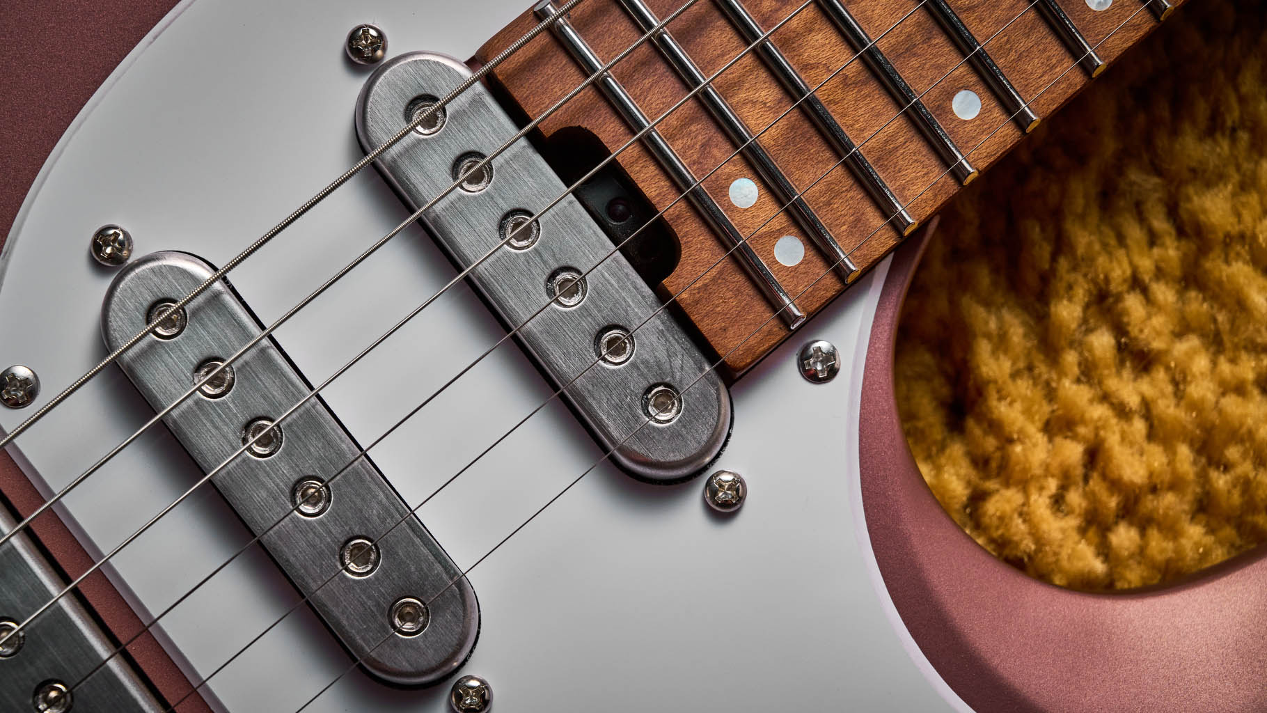Ibanez Q54W: the headless electric guitar is finished in Copper Metallic Matte and photographed against a thick light-tan colored carpet.
