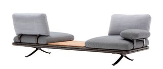 Grey modular sofa with chairs facing in opposite directions, separated by a table