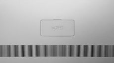 A photo of the underside of a Dell XPS laptop, showing the XPS logo on brushed silver metal and vents beneath.
