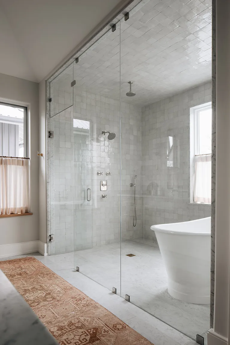 Bathroom with encased shower and bath area, and terracotta rug lining sink area