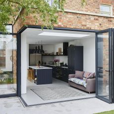 exterior of house with black and white kitchen and bifold doors