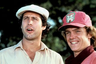 chevy chase in a golf uniform looking surprised in the movie caddyshack