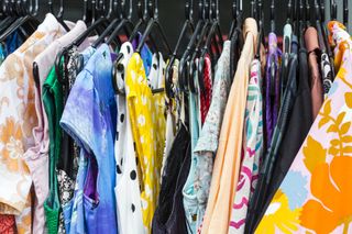 Second hand clothing displayed for sale outdoors on coat hangers