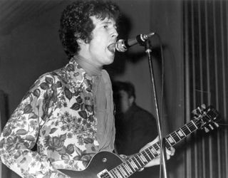 Rock and roll guitarist Eric Clapton of the rock band "Cream" performs onstage with a Gibson Les Paul electric guitar wearing a psychedelic shirt in circa 1968.