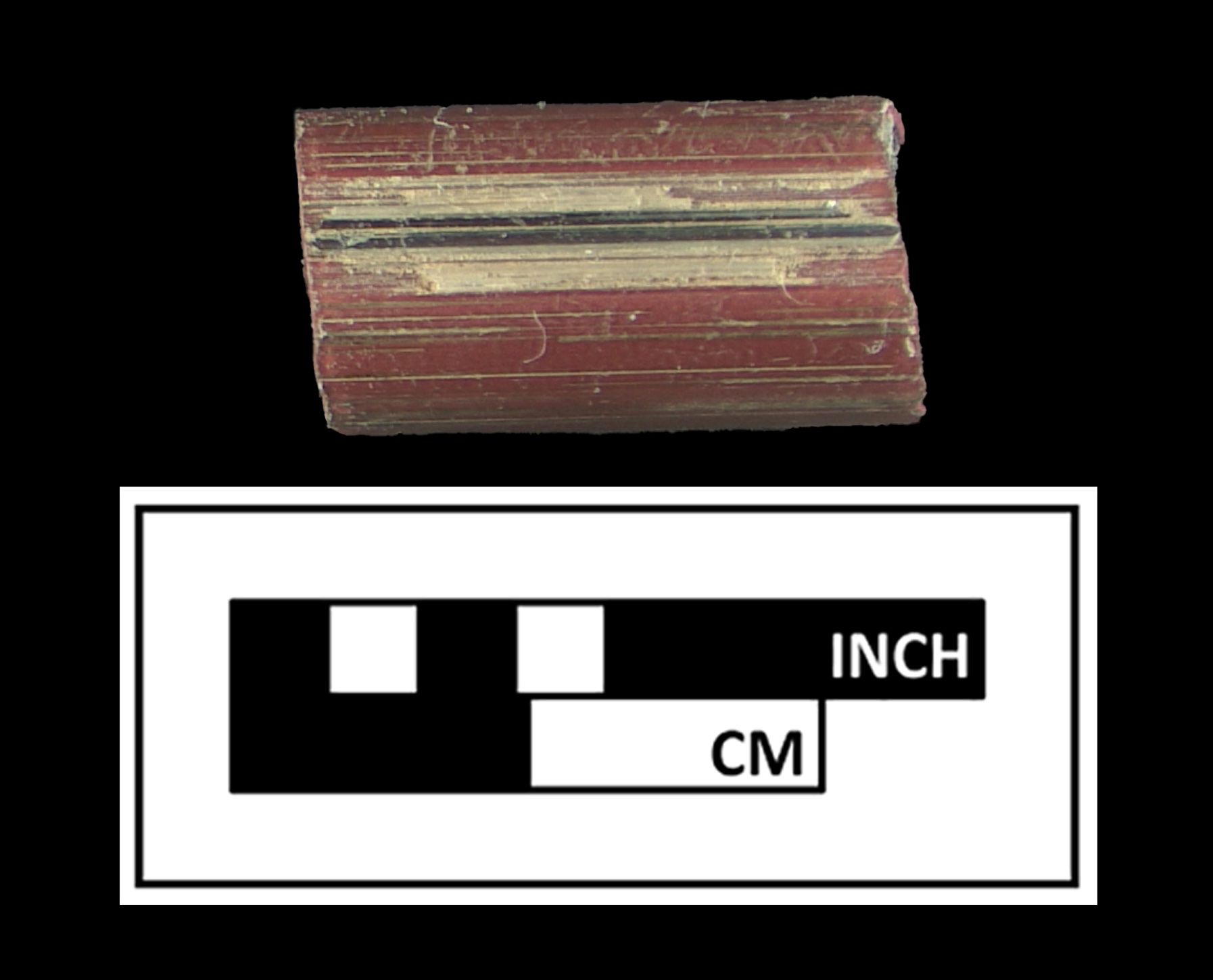 A reddish rectangular object next to a ruler