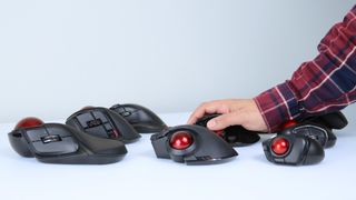 A hand trying out one of many trackball mice from ELECOM