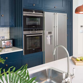 navy blue kitchen with large american style fridge and island