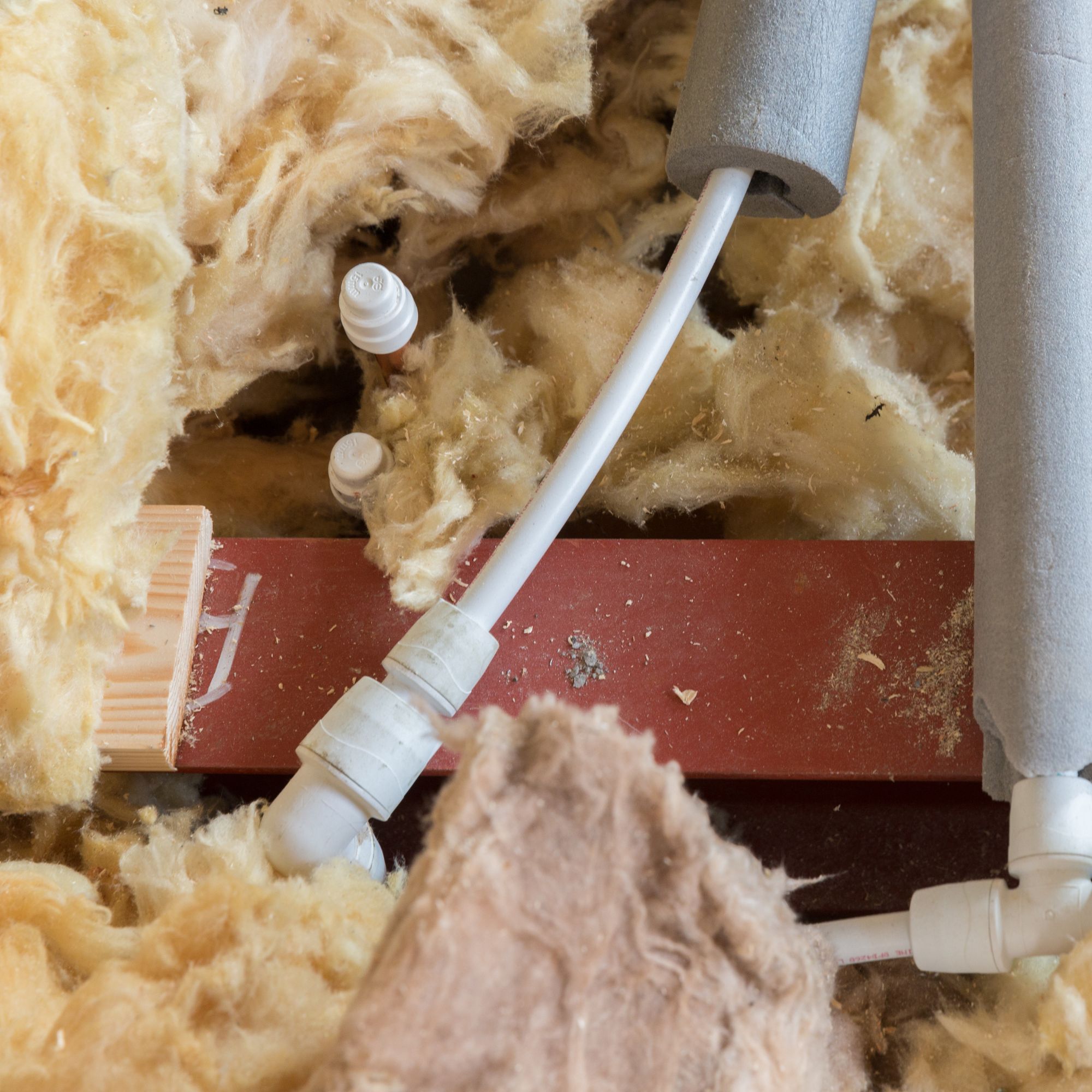 pipes insulated in loft space, laid over mineral wool loft insulation