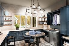 large laundry room with dramatic light fixture and blue cabinets