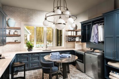 large laundry room with dramatic light fixture and blue cabinets