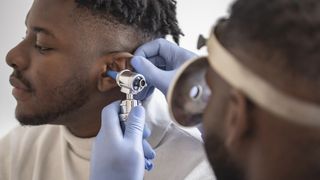 Doctor looks inside a man's ear