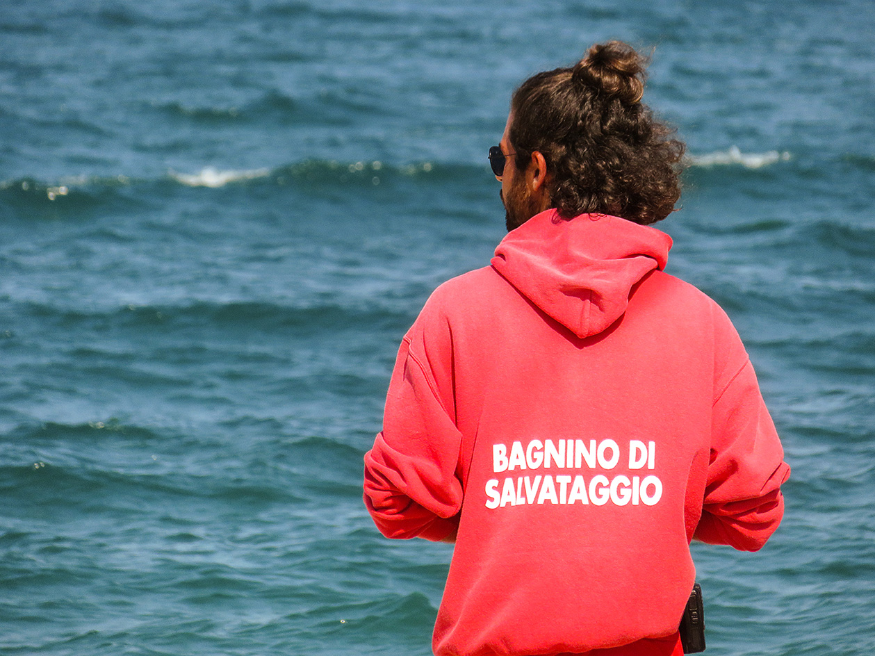 lifeguard in Italy wearing the lifeguard's uniform in red