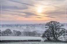 A sunrise over fields covered in frost