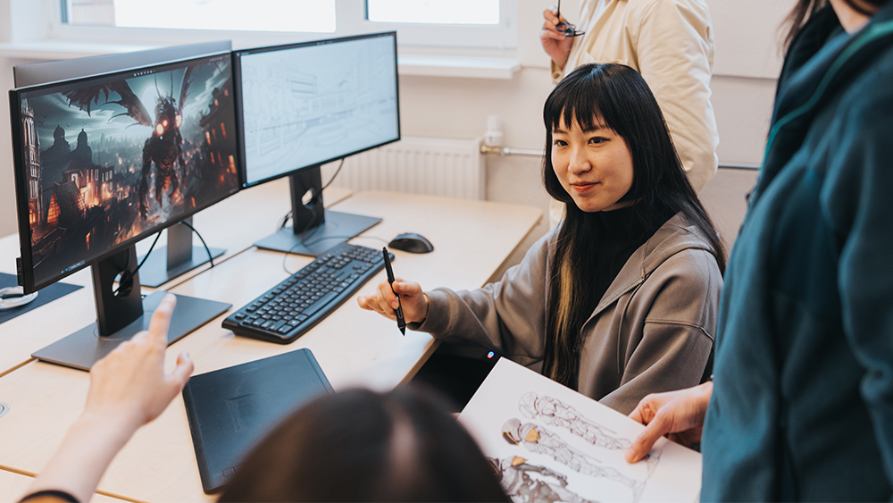 An image of a team of game designers getting started in game design with computer screens showing game creation
