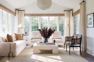 sunroom with white sofas and chandelier