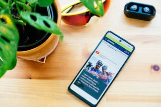 A cycling enthusiast's phone laying on a wooden table and displaying their favourite website