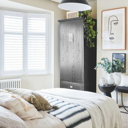 A white bedroom with a black wardrobe and accessories