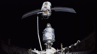 two space station modules are brought together in space using a robotic arm from a space shuttle