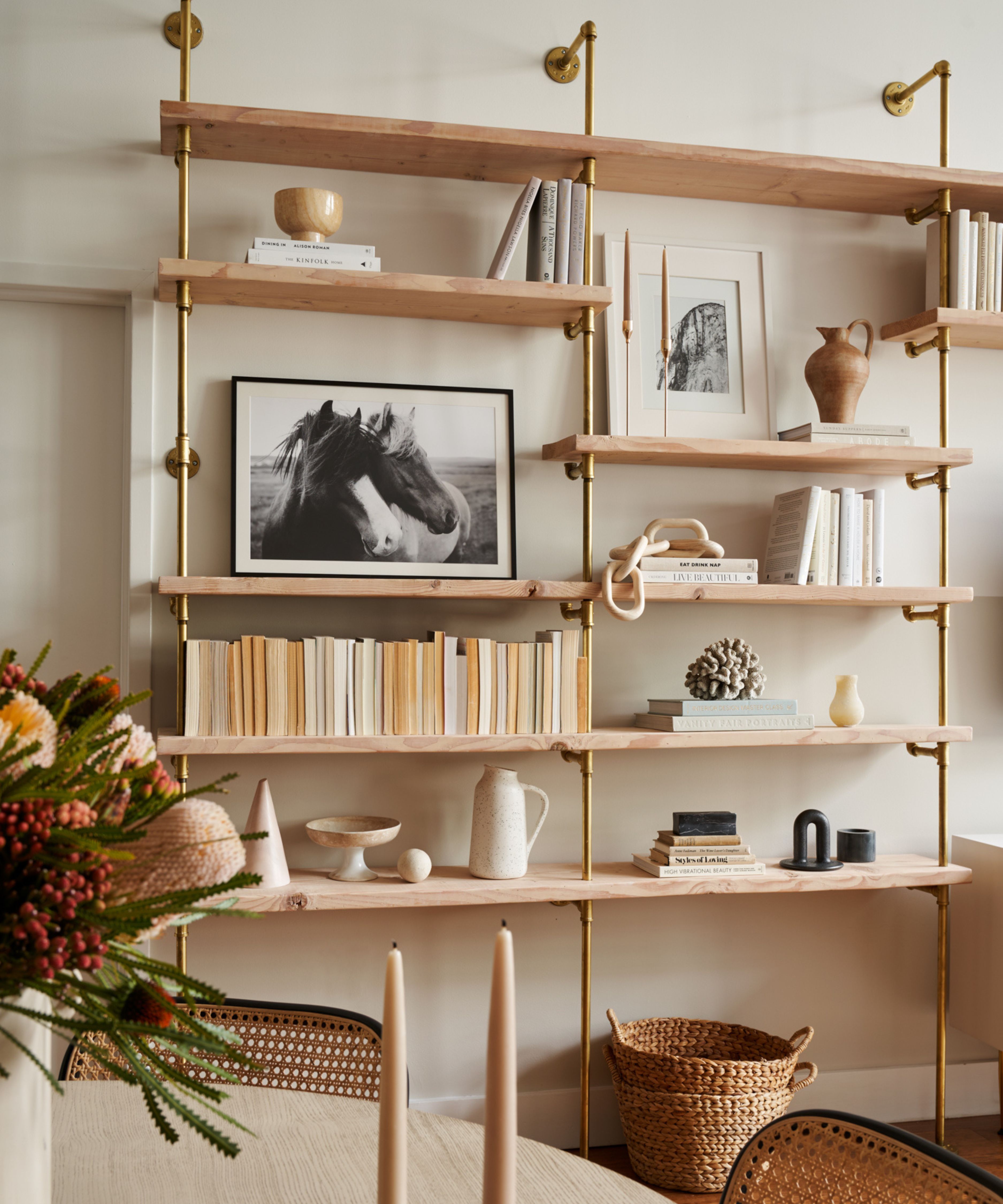 warm minimalist room with wood and brass open shelving styled with neutral decor