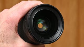 Nikon Z 35mm f/1.2 S product shot with lens held in hand