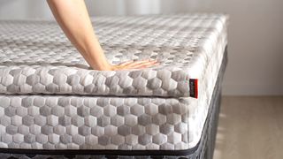 Layla Memory Foam Mattress review: A woman places her hand on top of the mattress to test how supportive it is
