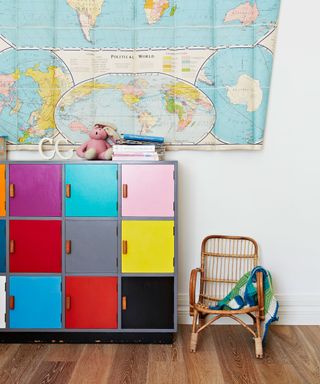 Unisex nursery ideas featuring colorful locker storage, a wicker chair and large map of the world.