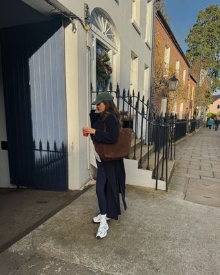 @kimturkington_ wearing long leggings, trainers and long coat with suede bag