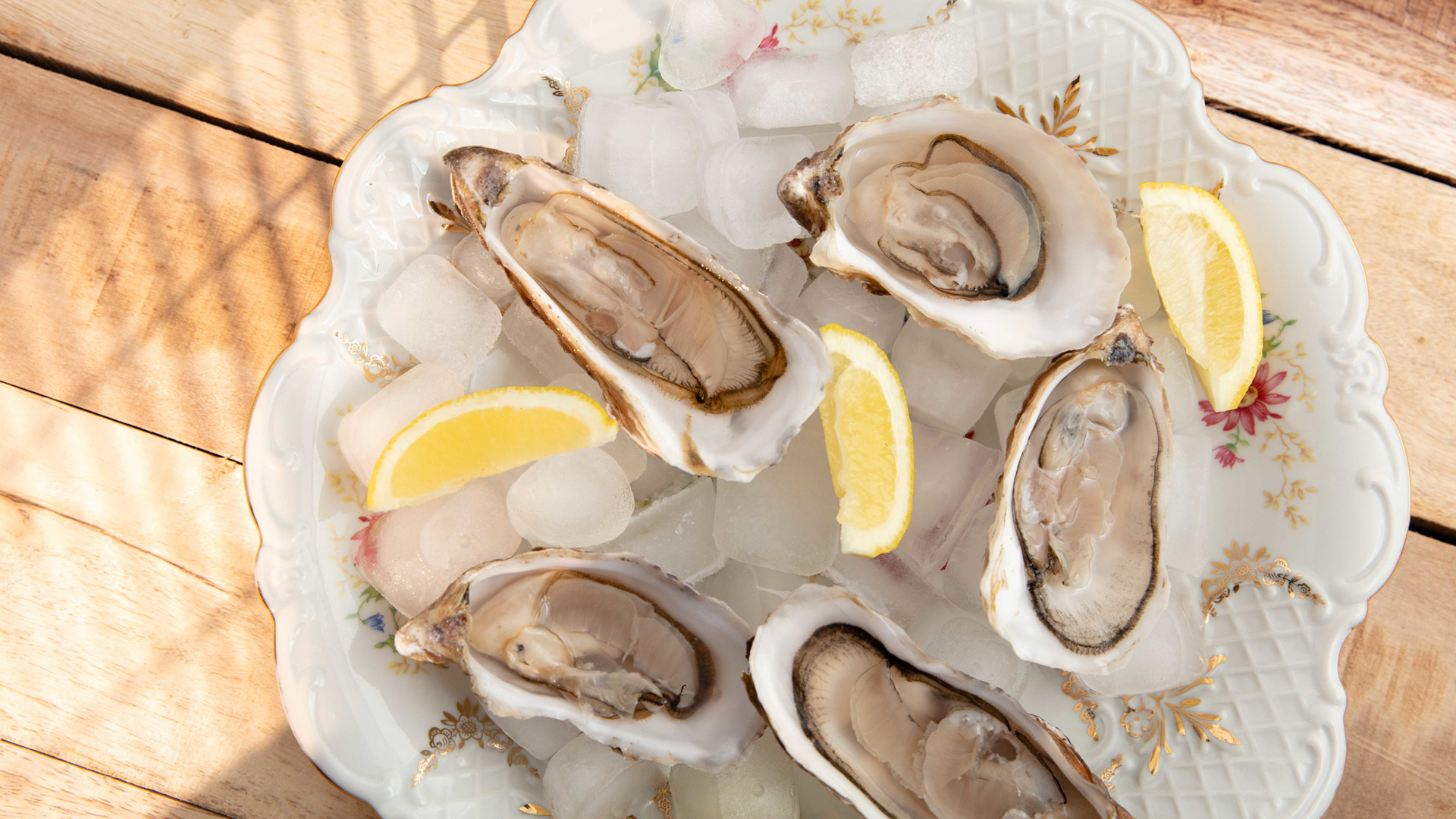 Oysters and lemon wedges on a patterned plate