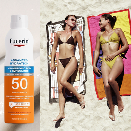 Two women wearing bikinis and layong on towels on the beach. Next to them is a bottle of spray sunscreen.