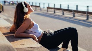 Woman relaxing with JBL Tune 660NC headphones.