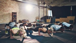 Group of people performing press-ups in the gym
