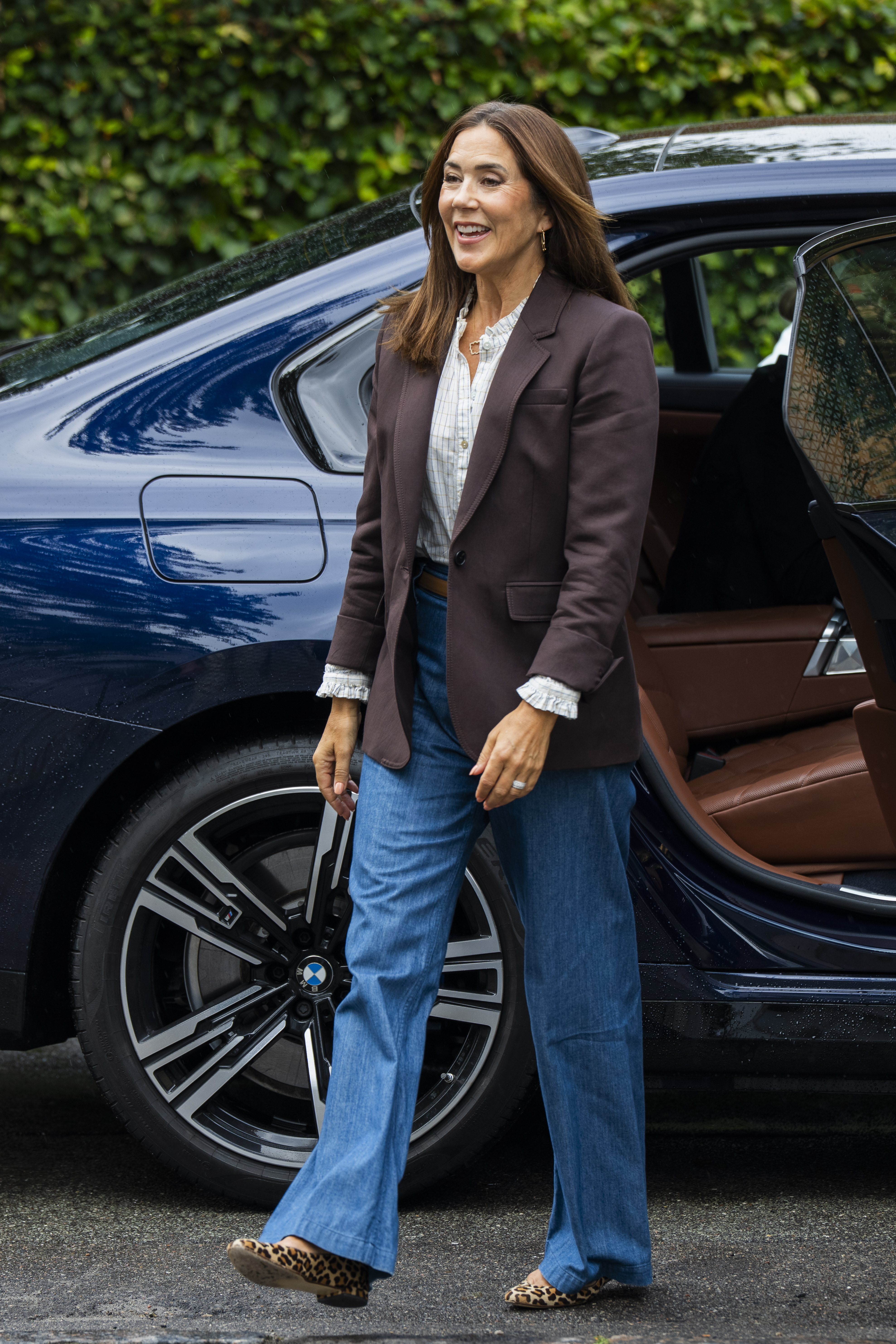 Queen Mary of Denmark getting out of a car in a brown blazer and jeans