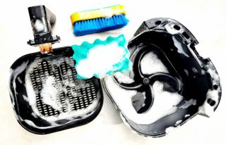 Cleaning an air fryer in parts using a sponge and soapy water